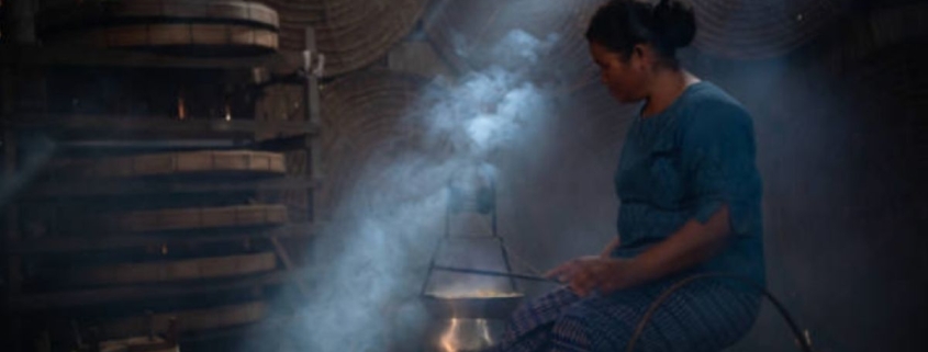အမျိုးသမီးတစ်ဦး မြန်မာမီးဖိုချောင်တွင်ချက်ပြုတ်နေသည်
