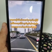 Hand holding a phone showing a TikTok video advertising factory job recruitment with high pay for young workers, illustrating the online job scams targeting unemployed garment workers